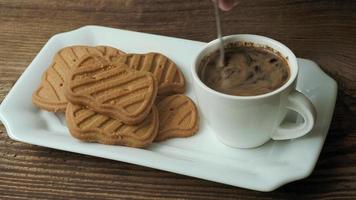 xícara de café com biscoitos em uma mesa de madeira. video