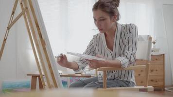 artista profesional usa pincel en arte abstracto para crear una obra maestra. pintura de pintor con acuarelas o aceite en casa de estudio. mujer disfruta pintando como hobby. recreación laboral video