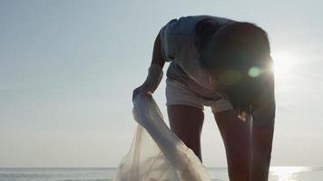 salvar a los voluntarios del mundo recoger basura en la playa y las botellas de plástico son difíciles de descomponer para evitar dañar la vida acuática. tierra, ambiente, planeta verde, reducir el calentamiento global, salvar el mundo video