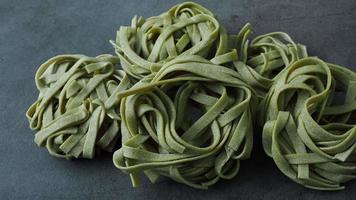 Fresh homemade green pasta tagliatelle. Raw homemade spinach pasta. Fettuccine pasta raw. Nest of green tagliatelle. video