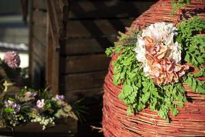 Beautiful background of twigs. Woven basket with flower. Street installation in spring. photo