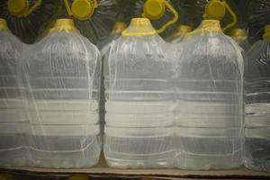 Bottles of water in film. Sale of drinking water. Canisters with fresh liquid. photo