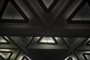 Light of lamps on ceiling. Architecture details. Triangles in building. photo