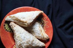 Turnovers Apple, Apple Pie, Served in an Orange Plate on a black cloth background, Turnovers Apple is a popular dish in America - Flat-Lay.