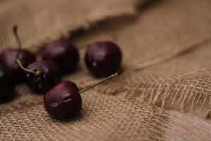 purple cherries placed on a cloth sack photo