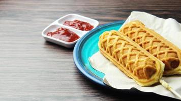 palitos de gofre perros de maíz gofres de perrito caliente en un palo ketchup en una mesa de madera foto