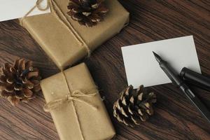 Se están preparando cajas de regalo de cumpleaños envueltas en papel reciclado en la mesa, vista superior, flatlay. foto