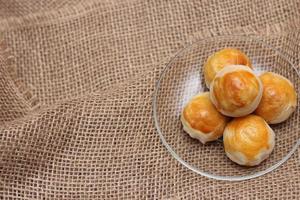 Chinese food moon cake or Chinese Pastry served on a glass plate placed on a light brown wooden table. photo