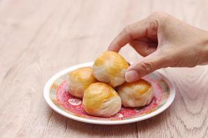 Chinese food moon cake or Chinese Pastry served on a glass plate placed on a light brown wooden table. photo