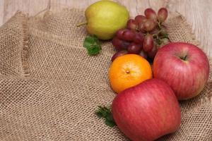 frutas con vitamina c que son beneficiosas para el organismo. colocar sobre tela de saco - naranja, uva, manzana, guayaba foto