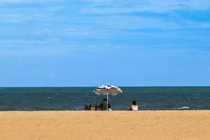 Sao Joao da Barra, RJ, Brazil, 2022 - A bather watches the sea under an umbrella on the Grussai Beach photo