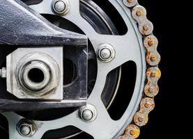 Motorcycle sprocket with rusty chain isolated on black blackground photo