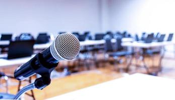 Close up microphone for speaker with copy space and laptop on table background in seminar room photo