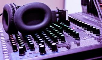 Auriculares negros en la mesa de mezclas de la placa de sonido de la consola foto