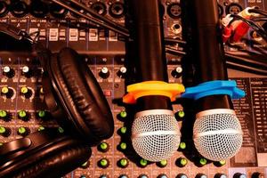 Top view black headphone and two microphone on console sound board mixer photo