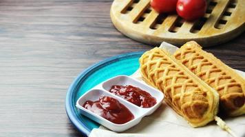 palitos de gofre perros de maíz gofres de perrito caliente en un palo ketchup en una mesa de madera foto