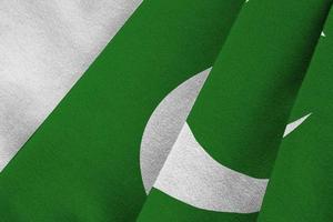 Pakistan flag with big folds waving close up under the studio light indoors. The official symbols and colors in banner photo