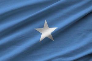 Somalia flag with big folds waving close up under the studio light indoors. The official symbols and colors in banner photo