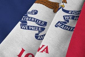 Iowa US state flag with big folds waving close up under the studio light indoors. The official symbols and colors in banner photo