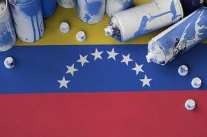 bandera de venezuela y pocas latas de aerosol usadas para pintar graffiti. concepto de cultura de arte callejero foto