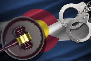 Colorado US state flag with judge mallet and handcuffs in dark room. Concept of criminal and punishment photo