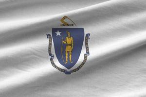 Massachusetts US state flag with big folds waving close up under the studio light indoors. The official symbols and colors in banner photo