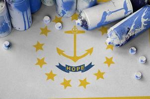 Rhode Island US state flag and few used aerosol spray cans for graffiti painting. Street art culture concept photo