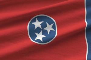 la bandera del estado de tennessee us con grandes pliegues ondeando de cerca bajo la luz del estudio en el interior. los símbolos y colores oficiales en banner foto