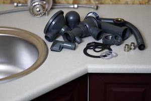 Tools and water tap ready for installation sink on countertop photo