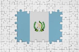 bandera de guatemala en el marco de piezas de un rompecabezas blanco con la parte central faltante foto