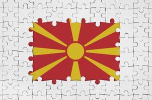 Macedonia flag in frame of white puzzle pieces with missing central part photo