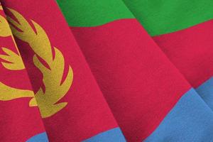 Eritrea flag with big folds waving close up under the studio light indoors. The official symbols and colors in banner photo