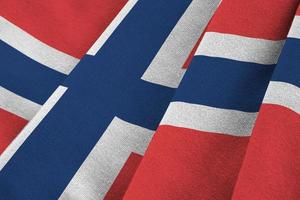 Norway flag with big folds waving close up under the studio light indoors. The official symbols and colors in banner photo