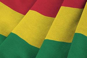 Bolivia flag with big folds waving close up under the studio light indoors. The official symbols and colors in banner photo