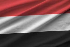 bandera de yemen con grandes pliegues ondeando de cerca bajo la luz del estudio en el interior. los símbolos y colores oficiales en banner foto