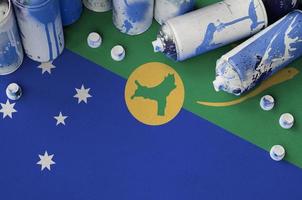 bandera de la isla de navidad y pocas latas de aerosol usadas para pintar graffiti. concepto de cultura de arte callejero foto