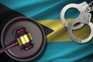 Bahamas flag with judge mallet and handcuffs in dark room. Concept of criminal and punishment, background for judgement topics photo