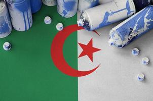 Algeria flag and few used aerosol spray cans for graffiti painting. Street art culture concept photo