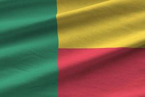 Benin flag with big folds waving close up under the studio light indoors. The official symbols and colors in banner photo