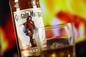 KYIV, UKRAINE - MAY 4, 2022 Captain Morgan original alcohol bottle on wooden table with fireplace photo