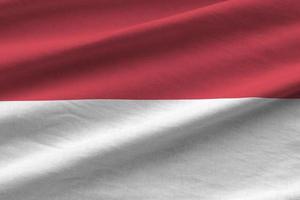 Monaco flag with big folds waving close up under the studio light indoors. The official symbols and colors in banner photo