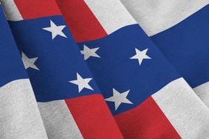 Netherlands Antilles flag with big folds waving close up under the studio light indoors. The official symbols and colors in banner photo