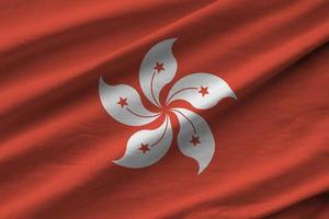 bandera de hong kong con grandes pliegues ondeando de cerca bajo la luz del estudio en el interior. los símbolos y colores oficiales en banner foto