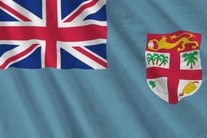 Fiji flag with big folds waving close up under the studio light indoors. The official symbols and colors in banner photo