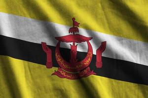 Brunei Darussalam flag with big folds waving close up under the studio light indoors. The official symbols and colors in banner photo