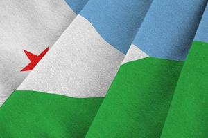 Djibouti flag with big folds waving close up under the studio light indoors. The official symbols and colors in banner photo