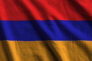 Armenia flag with big folds waving close up under the studio light indoors. The official symbols and colors in banner photo