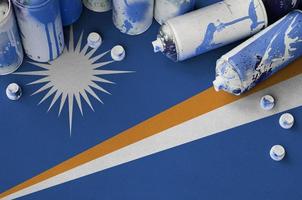 Marshall Islands flag and few used aerosol spray cans for graffiti painting. Street art culture concept photo