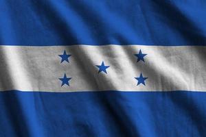 Honduras flag with big folds waving close up under the studio light indoors. The official symbols and colors in banner photo