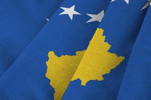 bandera de kosovo con grandes pliegues ondeando de cerca bajo la luz del estudio en el interior. los símbolos y colores oficiales en banner foto